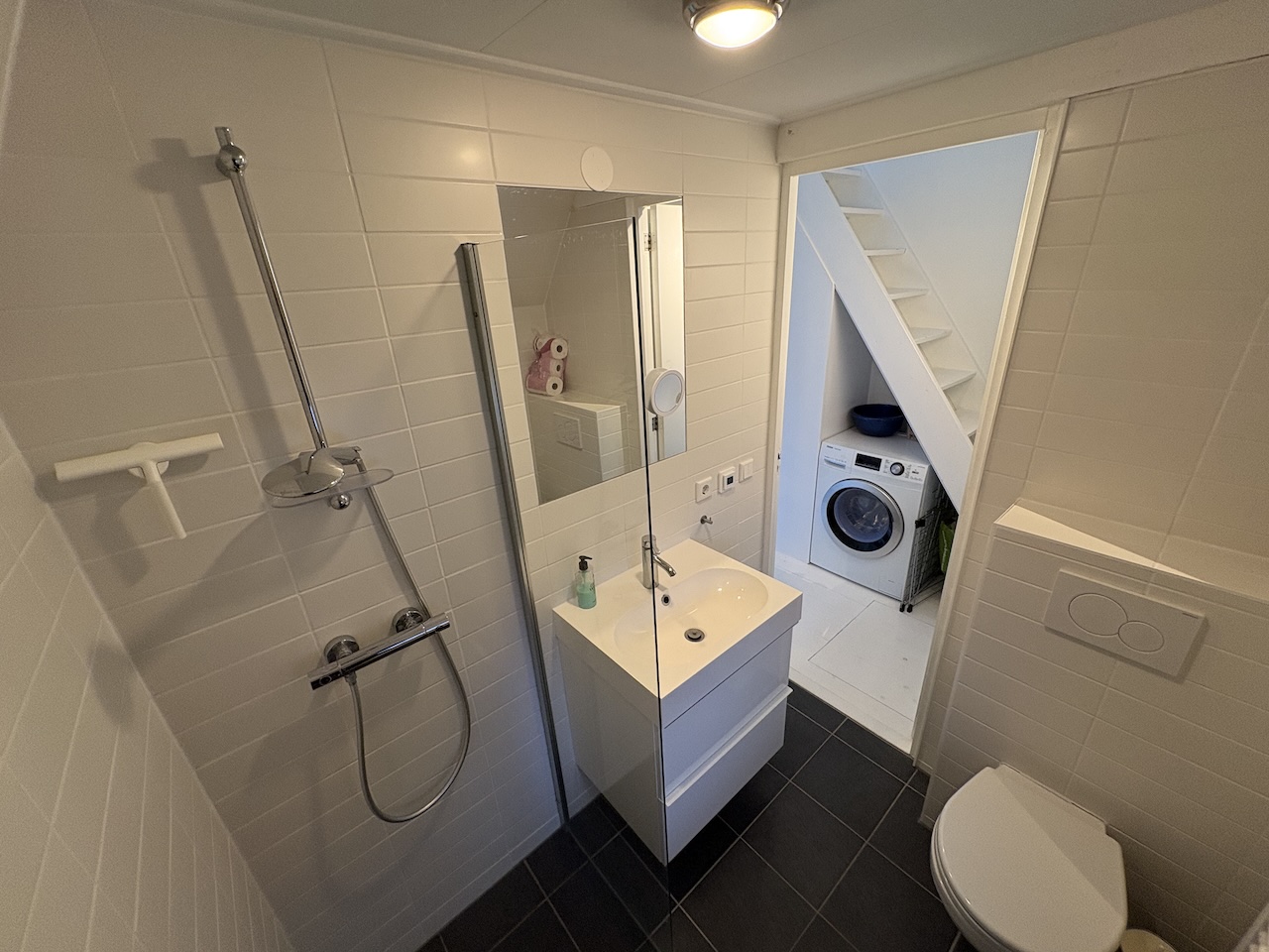 Badkamer met douche en doorgang naar de wasruimte